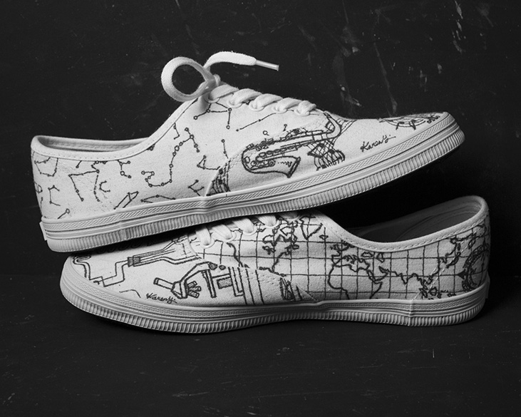 White Converse shoes with black illustrations (side view)