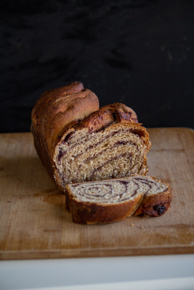 Loaf of sliced homemade babka bread on black background