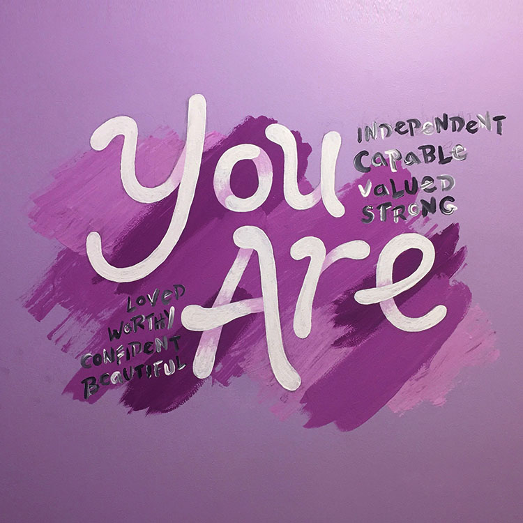 Purple mural with the words YOU ARE and several positive adjectives